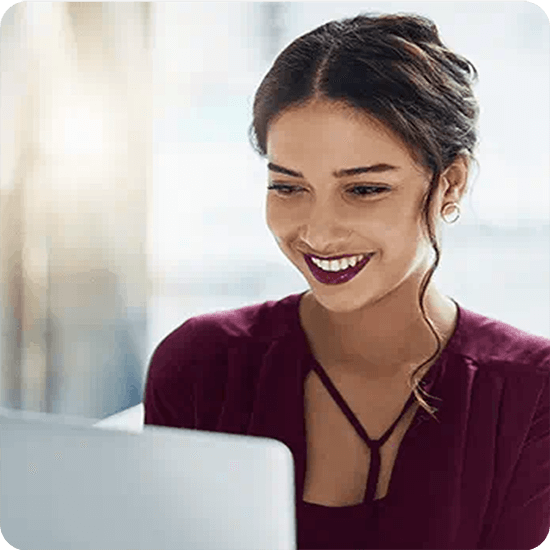 A smiling woman in front of a laptop