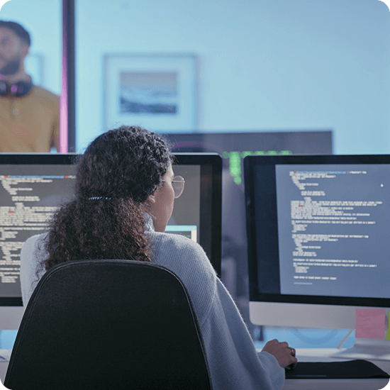 Person working in front of two computer monitors