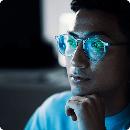 Profile of a man with glasses looking at a screen