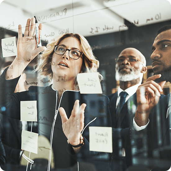 Several people looking at notes on a digital wall