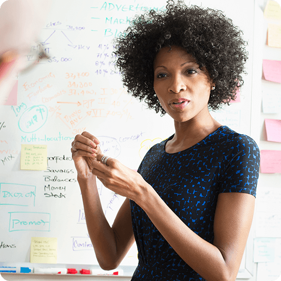 A woman giving a lecture at a white board