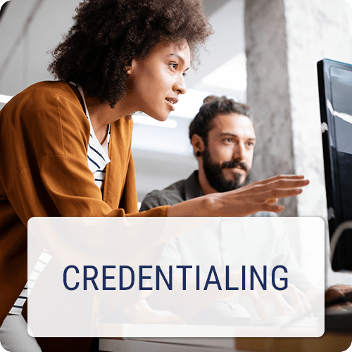 Two people looking at a desktop monitor