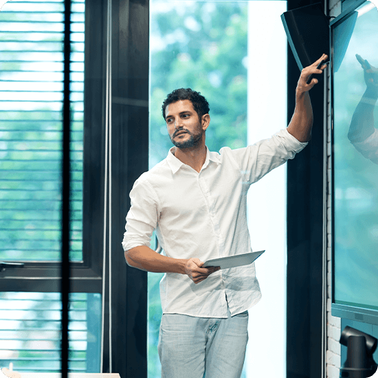 A man pointing to a white board